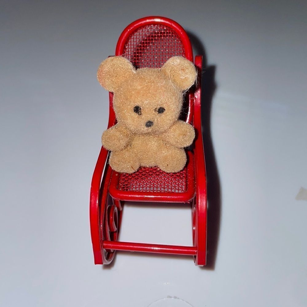Small vintage brown teddy bear on red metal rocker toy or decoration